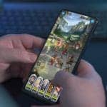person playing afk game on mobile phone